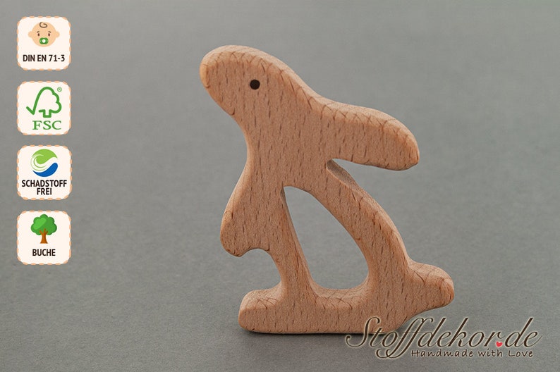 May include: A wooden bunny rabbit toy made from beech wood. The toy is unfinished and has a natural wood color. The toy is designed for babies and toddlers and is safe for chewing. The toy is made in Germany and is certified by the FSC and DIN EN 71-3.