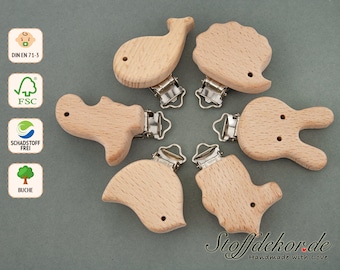 May include: Six wooden baby teethers in various animal shapes, including a whale, hedgehog, dinosaur, bunny, and two birds. Each teether has a silver clip attached for easy fastening to a stroller or diaper bag. The teethers are made of natural beech wood and are certified safe for babies.