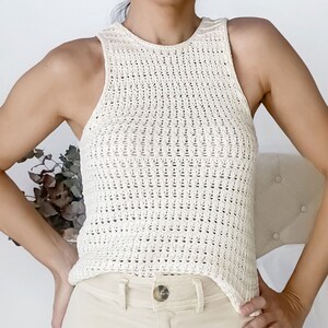 May include: A white crochet tank top with a high neckline and a loose fit.