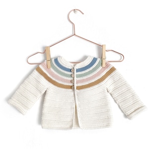 May include: A white crocheted baby cardigan with a rainbow stripe pattern around the neckline. The cardigan has a button closure and long sleeves.