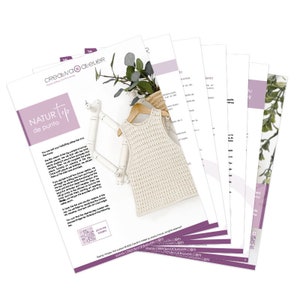 May include: A white crochet top with a sleeveless design. The top is laid out on a wooden hanger with a leafy green plant in the background. The text "NATUR Top de punto" is visible on the page.