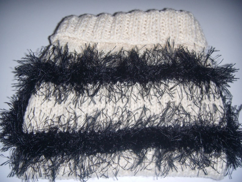 Dachshund dog sweater in chunky cream knit trimmed with black fun fur knitting yarn fringe.