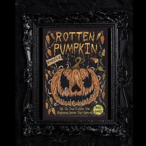 Puede incluir: Una ilustración enmarcada en negro de una calabaza podrida con el texto "ROTTEN PUMPKIN" en letras doradas. La calabaza está rodeada de gusanos y hojas. El texto "SPOOKTACULAR" está escrito en una pancarta sobre la calabaza. El texto "Dig The Dead Gourds This Halloween Before They Explode!" está escrito debajo de la calabaza. El texto "OOEY GOOBY" está escrito en un círculo debajo del texto.