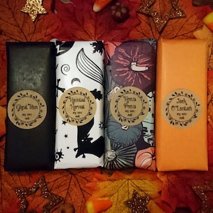Puede incluir: Cuatro ceras de soja con temática de Halloween envueltas en papel decorativo. Las etiquetas dicen "Ghost Train", "Haunted Harvest", "Hocus Pocus" y "Jack O'Lantern". El fondo presenta hojas de otoño, caramelos y decoraciones de estrellas.