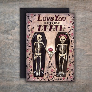 Puede incluir: Una tarjeta de felicitaci&oacute;n con una ilustraci&oacute;n de acuarela de dos esqueletos tomados de la mano en ata&uacute;des. Los esqueletos llevan coronas de flores y el texto "Love You To Death" est&aacute; escrito encima de ellos.