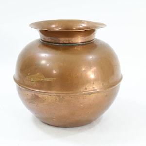 Op de afbeelding: Een ronde koperen vaas met een gegolfde rand. De vaas heeft een glad, glanzend oppervlak en een licht verweerde patina.