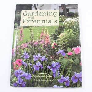 May include: Book cover with a colorful garden scene featuring purple irises, pink roses, and white flowers. The title of the book is "Gardening with Perennials" and the author is Fern Marshall Bradley. The book is a Rodale Garden Book.