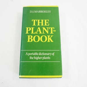 Peut inclure: Un livre vert intitulé "The Plant-Book" par D.J. Mabberley. Le sous-titre indique "A portable dictionary of the higher plants".