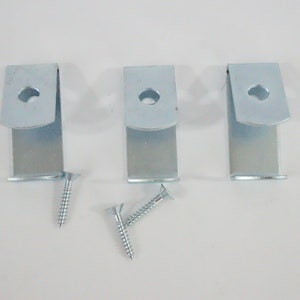 May include: Three silver metal shelf brackets with a hole in the center and three silver screws.