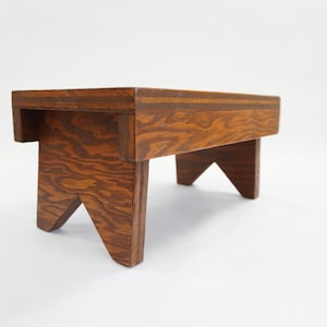 May include: A white ceramic mug with a black handle and the text "But First, Coffee" in a black, bold font. The mug is sitting on a wooden surface.