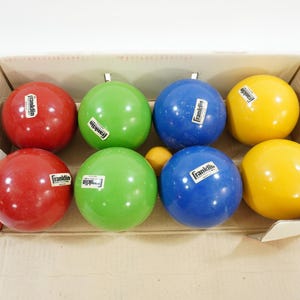 以下が含まれることがあります： 段ボール箱に入ったボッチェボール8個セット。ボールは赤、緑、青、黄色の4色。各ボールには「Franklin」の文字が印刷されています。