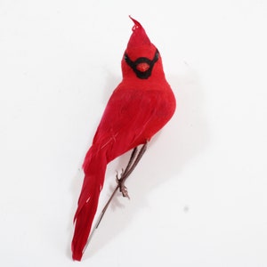 Puede incluir: Adorno de pájaro cardenal rojo brillante con máscara y pico negros. El pájaro está posado en una fina rama de alambre marrón. Las plumas del pájaro son de un rojo intenso y tiene una pequeña cresta en la cabeza. Ideal para decoración navideña.