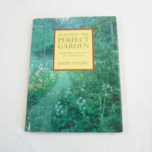 以下が含まれることがあります： 「Planting the Perfect Garden」というタイトルの本。表紙には庭の風景が描かれています。タイトルは赤い縁取りのある金色の枠内にあり、著者名であるDavid Stuartも表示されています。