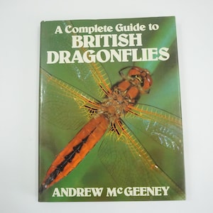 以下が含まれることがあります： アンドリュー・マギーニー著「A Complete Guide to British Dragonflies」というタイトルの本。表紙には、緑色の背景にオレンジと黒の模様のトンボがクローズアップされている。