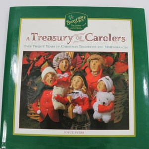 以下が含まれることがあります： 「A Treasury of Carollers」というタイトルの緑色の本で、赤と白の服を着た5人のクリスマスキャロル歌手がクリスマスキャロルを歌っている写真が載っています。この本はジョイス・バイアーズによるもので、バイアーズ・チョイスのロゴが掲載されています。