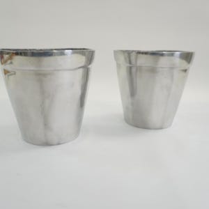 Può includere: Un set di tre tazze in ceramica con finitura opaca e macchiettata. Le tazze sono nei toni del crema, grigio chiaro e grigio scuro. Ogni tazza ha un design semplice e minimalista e un manico arrotondato.
