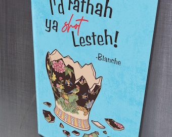 May include: A rectangular magnet with a light blue background featuring the text "I'd rathah ya shot Lesteh!" and a broken vase illustration. The vase has floral and gold accents. The magnet is attached to a metallic surface.
