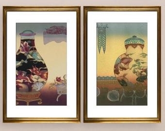 May include: Two framed art prints with gold frames. One print features a vase filled with flowers, the other depicts a figure with a patterned hat. The prints are displayed on a wooden console table with decorative white panels.