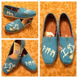 Könnte beinhalten: Ein Paar blaue Canvas-Schuhe mit weißen bemalten Designs. Ein Schuh sagt "I Do" und "7-19-14". Der andere Schuh sagt "Mrs." und "7-19-14".