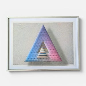 Op de afbeelding: Een ingelijste print met een grote driehoek met een blauw-naar-roze verloop en een rasterpatroon. Binnenin toont een kleinere driehoek horizontale strepen in diverse kleuren. De achtergrond is een getextureerd, lichtgrijs gespikkeld oppervlak.