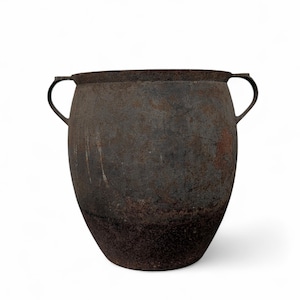 May include: A large, dark brown metal pot with two curved handles. The pot has a wide, rounded body and a slightly flared rim. The metal has a weathered, textured appearance, with areas of rust and discoloration.