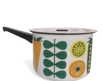 May include: White enamel saucepan with a black handle and a lid. The saucepan features a colourful design of vegetables, including carrots, peas, and a lemon.