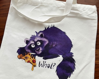 Könnte beinhalten: Weiße Stofftasche mit einem lila Waschbären, der ein Stück Pizza hält, und dem Text "What?" darauf gedruckt.