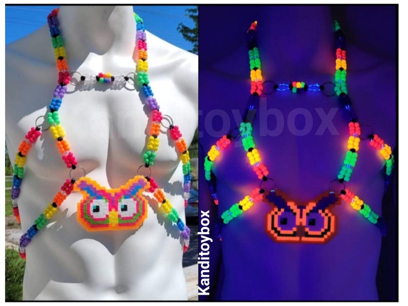 Peut inclure: Un harnais de corps compos&eacute; de perles en plastique multicolores dispos&eacute;es en arc-en-ciel, avec un pendentif central en forme de hibou. Le design inclut des anneaux m&eacute;talliques argent&eacute;s reliant les brins de perles qui brillent sous lumi&egrave;re UV.