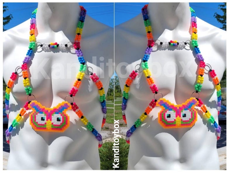 Peut inclure: Un harnais de corps compos&eacute; de perles en plastique multicolores dispos&eacute;es en arc-en-ciel, avec un pendentif central en forme de hibou fait de perles fusionn&eacute;es. Le design comprend des anneaux m&eacute;talliques argent&eacute;s reliant les brins de perles.