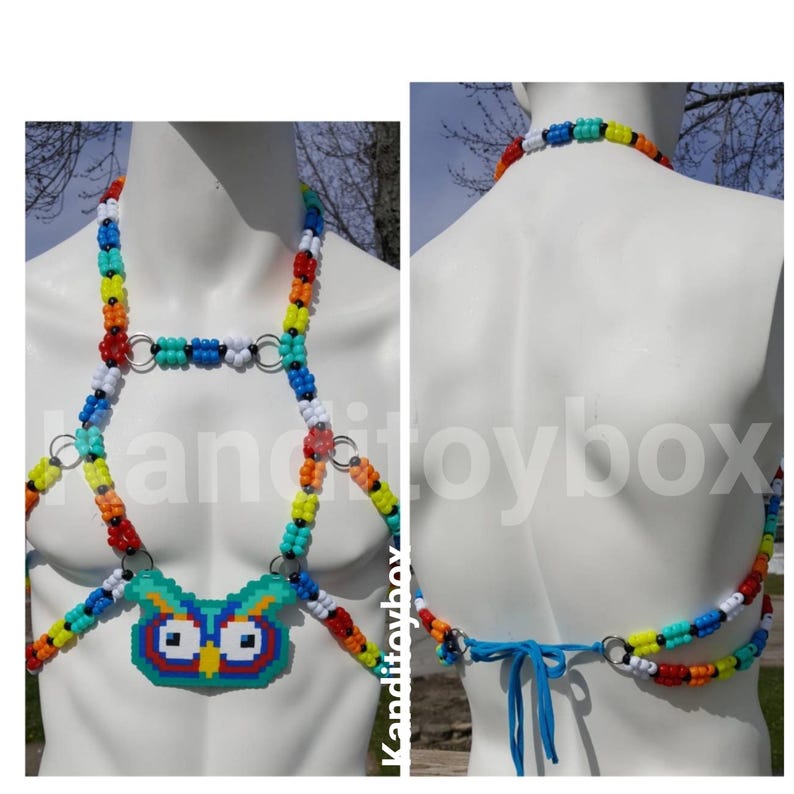 Peut inclure: Un harnais de corps en perles multicolores avec un pendentif central en forme de hibou pixelis&eacute; fait de perles en plastique. Le harnais est compos&eacute; de perles pony rouges, orange, jaunes, vertes, bleues et blanches reli&eacute;es par des anneaux en m&eacute;tal argent&eacute;.