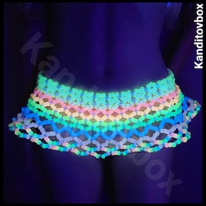 May include: A neon-colored, beaded skirt with a layered design. The skirt features a vibrant gradient of colors, including blue, green, yellow, and pink. The beads are arranged in a net-like pattern, creating a unique and eye-catching look.