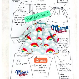 May include: A doll dress with a light blue background featuring a pattern of colorful rainbows, white clouds, and small hearts. The dress is placed on a paper sewing pattern sheet labeled Pattern no. 1, Dress, and Miema Dollhouse, with a 1 inch scale.