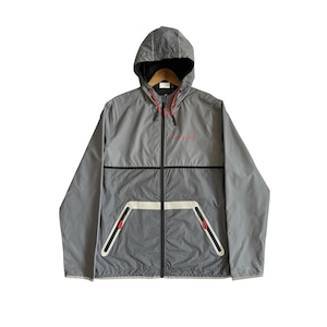 May include: A grey hooded windbreaker jacket featuring a black and white checkered pattern on the lower front and hood. The jacket includes a full-length black front zipper, two zippered pockets with white trim, and red accents on the zipper pulls.