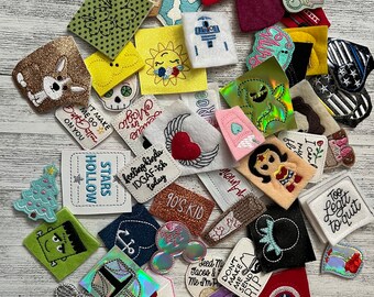 May include: A collection of colorful embroidered iron-on patches with various designs and sayings, including "Stars Hollow", "90's Kid", "Too Legit to Quit", and "Don't Make Me Send You To The Principal".