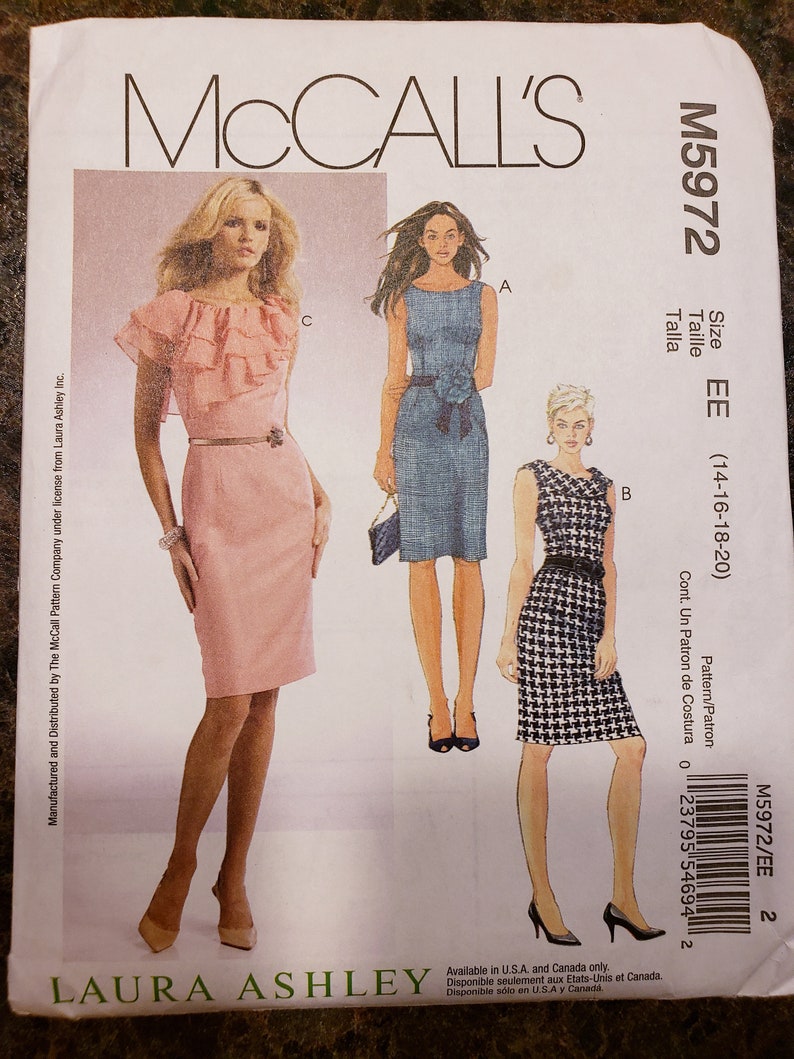 Może przedstawiać: Wz&oacute;r szycia sukienki od McCall's, z wzorem autorstwa Laury Ashley. Wz&oacute;r zawiera trzy r&oacute;żne style sukienek: r&oacute;żową sukienkę z falbankami, niebieską sukienkę z paskiem i czarno-białą sukienkę w kratę.