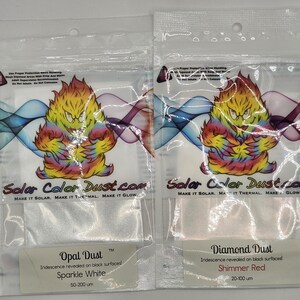 May include: Two clear plastic pouches of Solar Color Dust. One is labeled "Opal Dust" with "Sparkle White" and the other is "Diamond Dust" with "Shimmer Red". Each pouch features a colorful cartoon character.