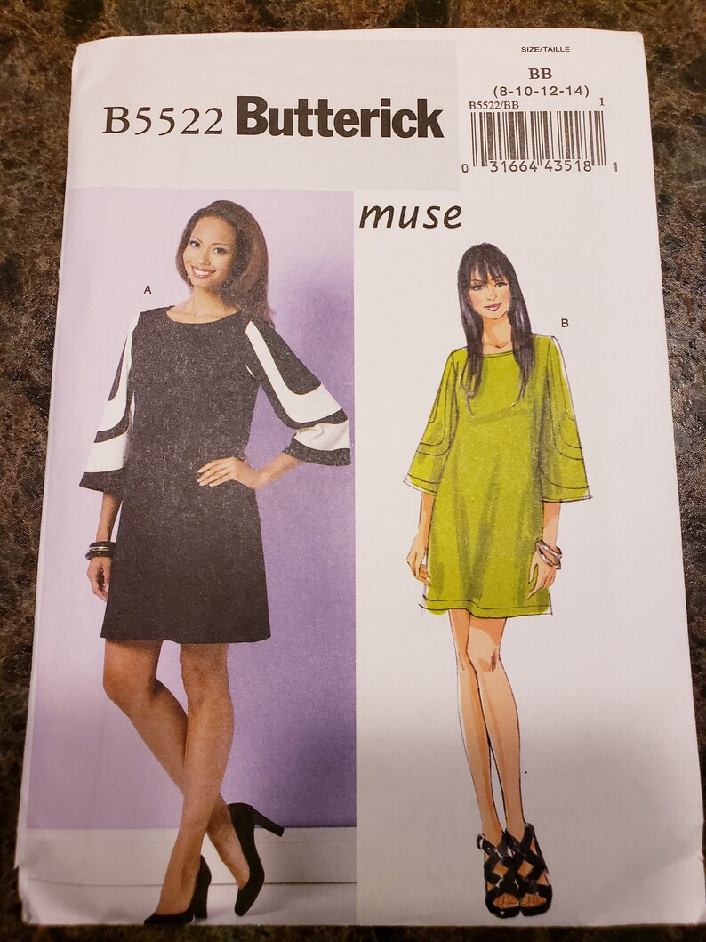 May include: A sewing pattern for a dress with a round neckline and short sleeves. The pattern is for sizes 8-10-12-14. The pattern is from Butterick and is called "muse".