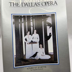 Puede incluir: Una portada de programa plateada y negra para el 25º aniversario de The Dallas Opera. La portada presenta una pintura de tres mujeres con vestidos blancos de pie en un bosque con cuervos negros. El texto "Roméo et Juliette de Charles Gounod" está impreso en la parte inferior.