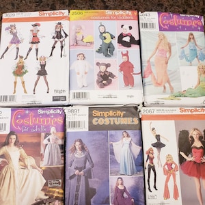 May include: A selection of Simplicity costume sewing patterns. The patterns showcase diverse costume designs for adults and children, including historical, fantasy, and animal-themed outfits. The covers display illustrations of the finished costumes.
