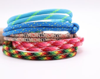 Peut inclure: Un ensemble de bracelets en paracorde colorés avec différents motifs. Les bracelets sont faits de cordon de nylon tissé et sont disponibles dans une variété de couleurs et de motifs.