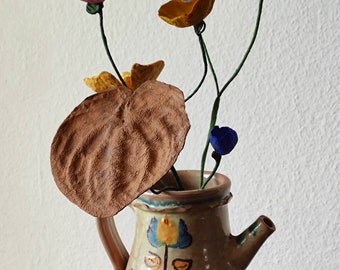 Samenstelling van papier-maché bloemen, keramische vaas met bloemen en bladeren van papier-maché, tafeldecoratie, woondecoratie, middelpunt