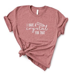 Puede incluir: Una camiseta color marrón rojizo con el texto "Tengo un cristal para eso" y un dibujo de un lápiz.
