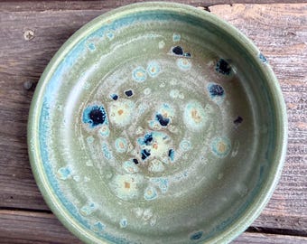 Plato pequeño curvo hecho a mano en torno y esmaltado en verde moteado.