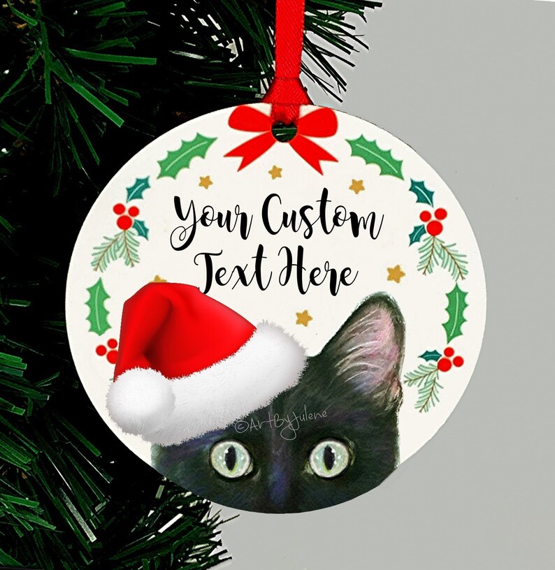 May include: Round Christmas ornament featuring a black cat wearing a red Santa hat peeking out from behind a green holly wreath with red berries and gold stars. The text "Your Custom Text Here" is written in black on the ornament.