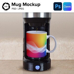 Puede incluir: Una cafetera negra con una taza de arcoíris encima. La taza está llena de café y la cafetera tiene un botón en la parte delantera.