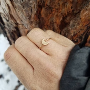May include: A gold crescent moon ring with a delicate wire design.