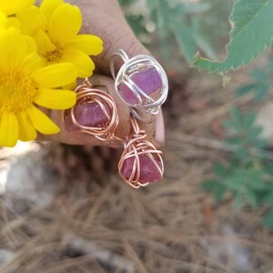 May include: Two wire wrapped rings with pink crystals. The rings are made with copper and silver wire.