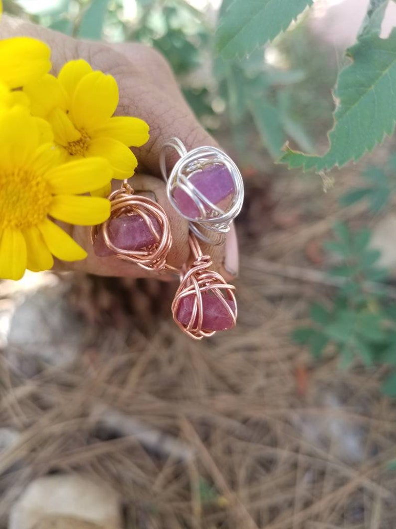 May include: Two wire wrapped rings with pink crystals. The rings are made with copper and silver wire.
