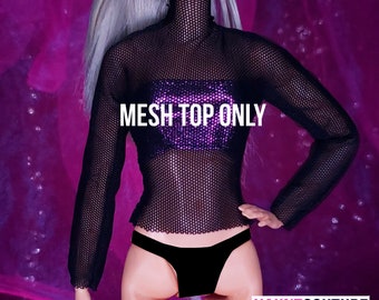 Può includere: Top a maniche lunghe in rete nera con collo alto. Il top è realizzato in un tessuto a rete fine e ha una silhouette aderente. "MESH TOP ONLY" è scritto in bianco sulla parte anteriore del top.