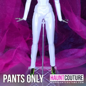 May include: White pants with a seam down the front of each leg. The pants are on a doll stand against a pink background. The text "PANTS ONLY" is at the bottom of the image.